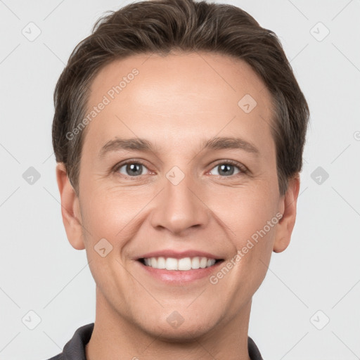 Joyful white young-adult male with short  brown hair and grey eyes