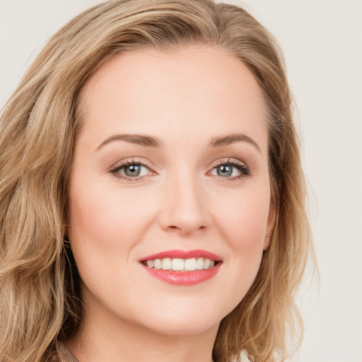 Joyful white young-adult female with long  brown hair and blue eyes