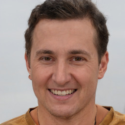 Joyful white adult male with short  brown hair and brown eyes