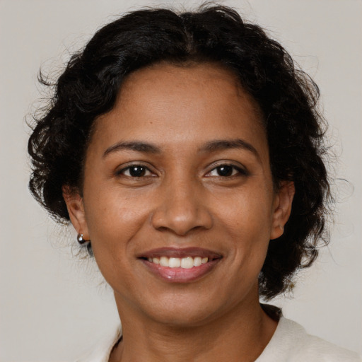 Joyful black adult female with short  brown hair and brown eyes