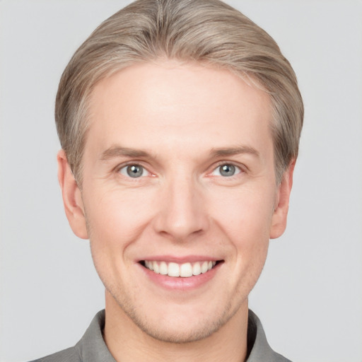 Joyful white adult male with short  brown hair and grey eyes