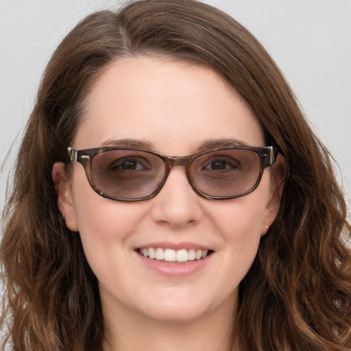 Joyful white young-adult female with long  brown hair and blue eyes