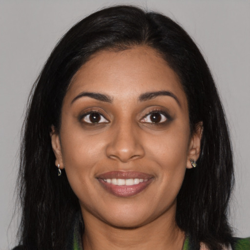 Joyful black young-adult female with long  black hair and brown eyes