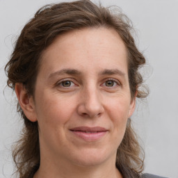 Joyful white adult female with medium  brown hair and grey eyes