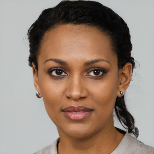 Joyful black young-adult female with short  black hair and brown eyes