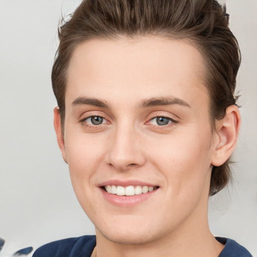 Joyful white young-adult female with short  brown hair and grey eyes