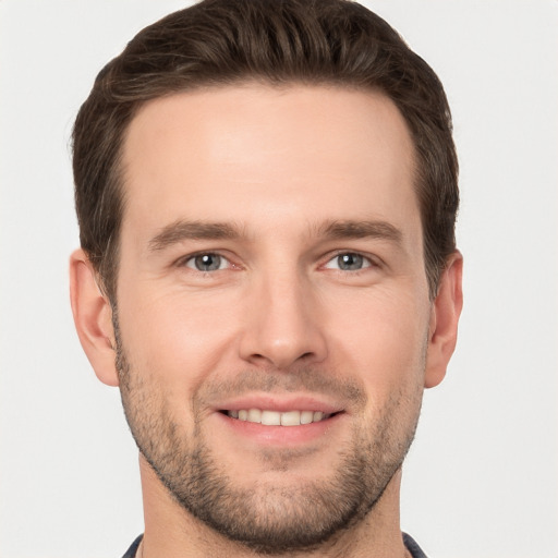 Joyful white young-adult male with short  brown hair and grey eyes