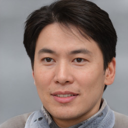 Joyful asian adult male with short  brown hair and brown eyes