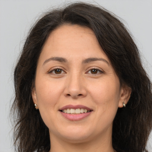 Joyful white adult female with long  brown hair and brown eyes