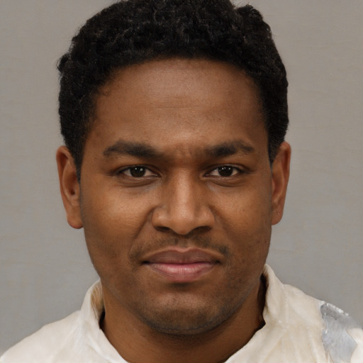 Joyful black young-adult male with short  black hair and brown eyes