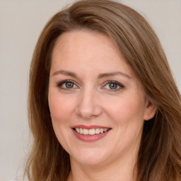 Joyful white young-adult female with long  brown hair and green eyes