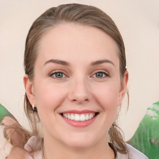 Joyful white young-adult female with medium  brown hair and green eyes