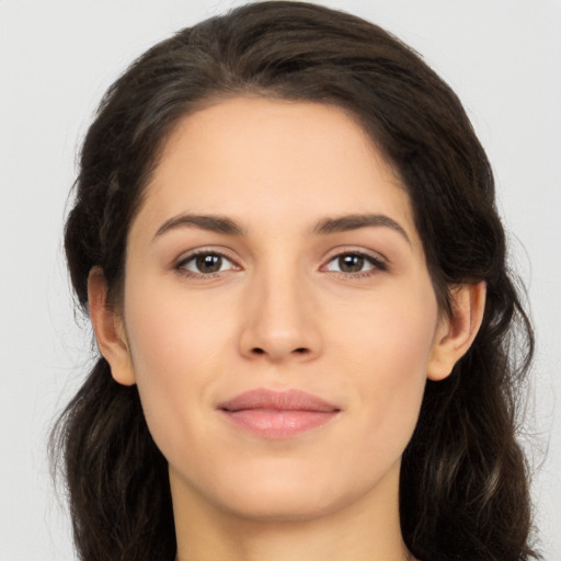 Joyful white young-adult female with long  brown hair and brown eyes