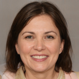 Joyful white adult female with medium  brown hair and brown eyes