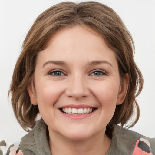 Joyful white young-adult female with medium  brown hair and grey eyes