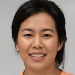 Joyful asian young-adult female with medium  brown hair and brown eyes