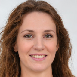 Joyful white young-adult female with long  brown hair and green eyes