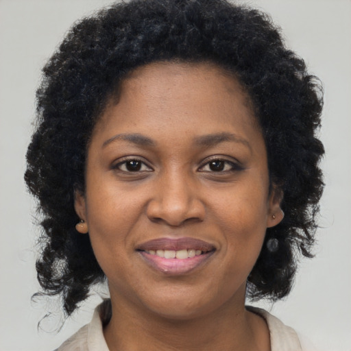 Joyful black adult female with medium  brown hair and brown eyes