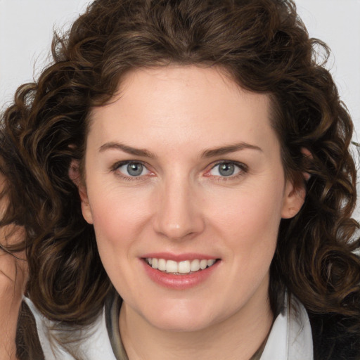 Joyful white young-adult female with medium  brown hair and green eyes