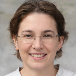 Joyful white adult female with medium  brown hair and grey eyes