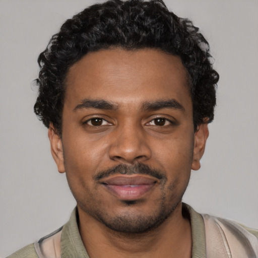 Joyful black young-adult male with short  black hair and brown eyes