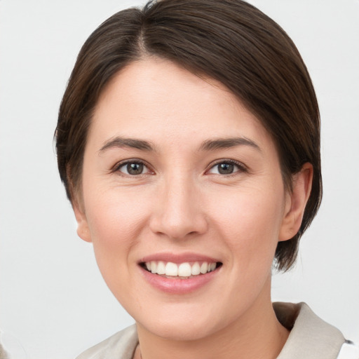 Joyful white young-adult female with medium  brown hair and grey eyes