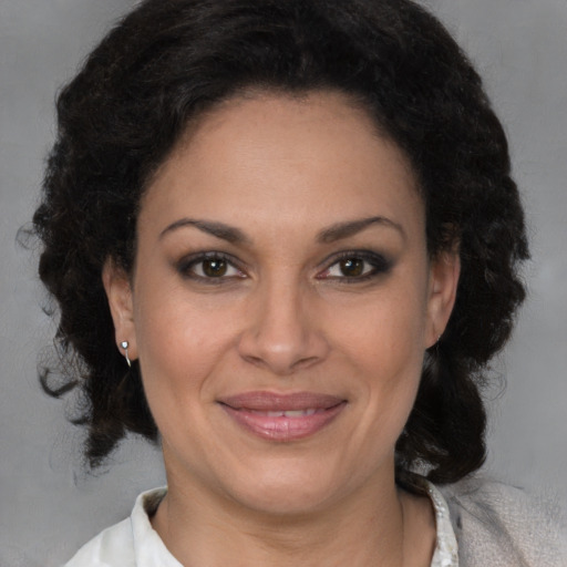 Joyful latino adult female with medium  brown hair and brown eyes