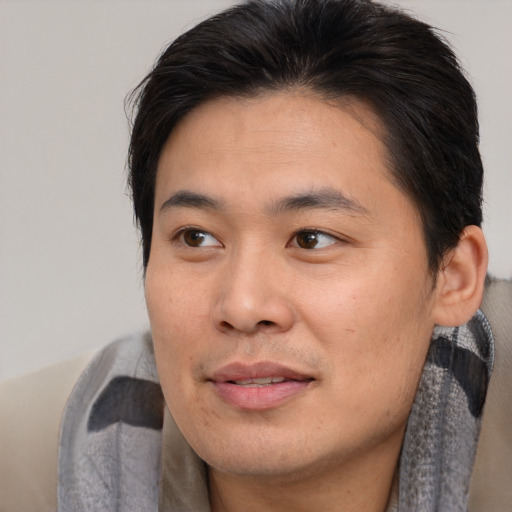 Joyful asian young-adult male with short  brown hair and brown eyes