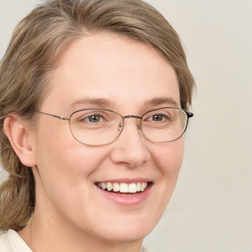 Joyful white adult female with medium  brown hair and green eyes