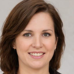 Joyful white young-adult female with long  brown hair and green eyes