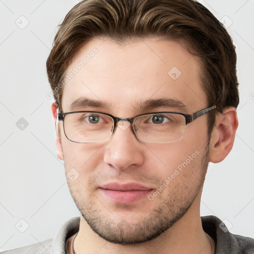 Joyful white young-adult male with short  brown hair and grey eyes