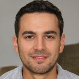 Joyful white young-adult male with short  brown hair and brown eyes