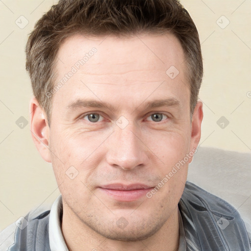 Joyful white young-adult male with short  brown hair and grey eyes