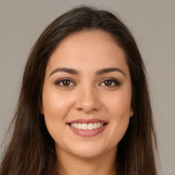 Joyful white young-adult female with long  brown hair and brown eyes