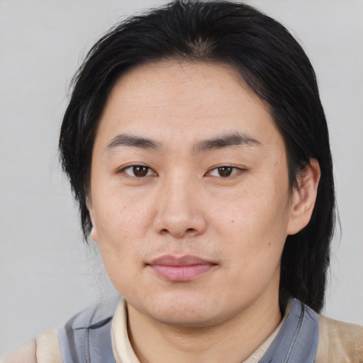 Joyful asian young-adult male with medium  black hair and brown eyes