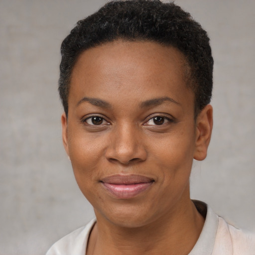 Joyful black young-adult female with short  black hair and brown eyes
