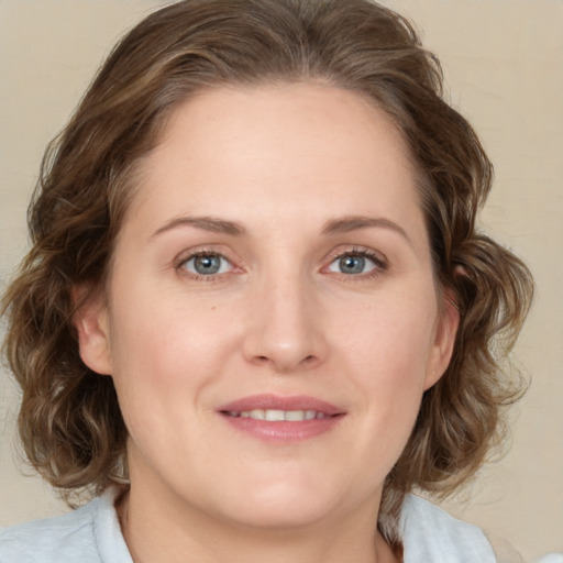 Joyful white young-adult female with medium  brown hair and blue eyes