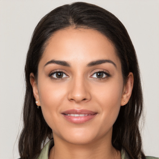 Joyful latino young-adult female with long  brown hair and brown eyes