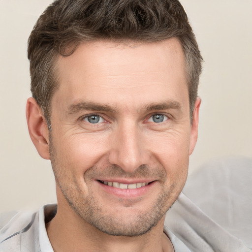 Joyful white adult male with short  brown hair and grey eyes