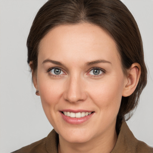 Joyful white young-adult female with medium  brown hair and grey eyes