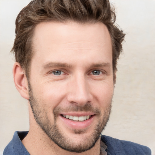 Joyful white young-adult male with short  brown hair and blue eyes