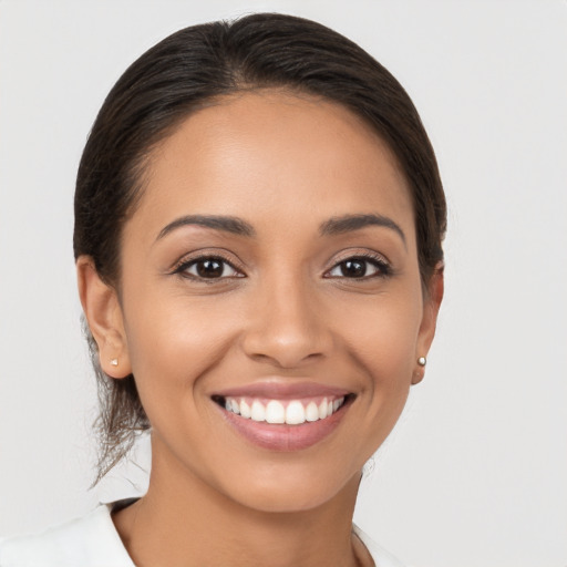 Joyful latino young-adult female with long  brown hair and brown eyes