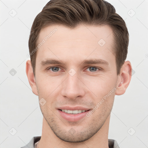 Joyful white young-adult male with short  brown hair and grey eyes