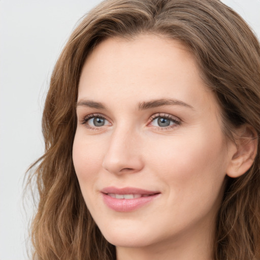 Joyful white young-adult female with long  brown hair and blue eyes