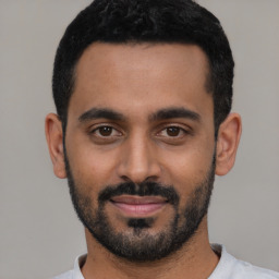 Joyful black young-adult male with short  black hair and brown eyes