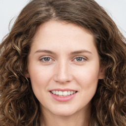 Joyful white young-adult female with long  brown hair and green eyes