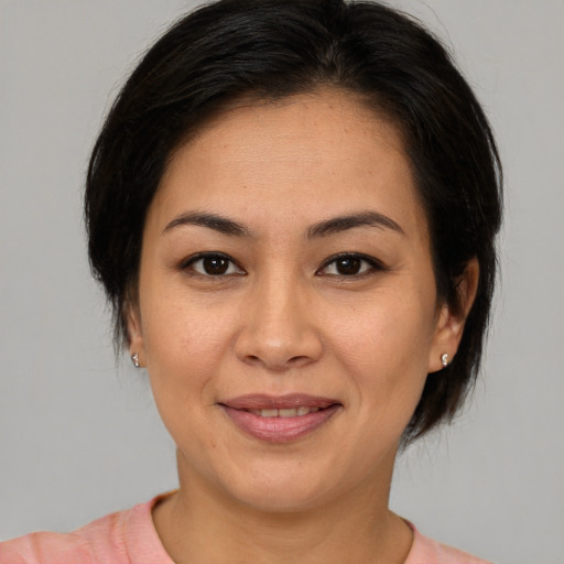 Joyful asian adult female with medium  brown hair and brown eyes