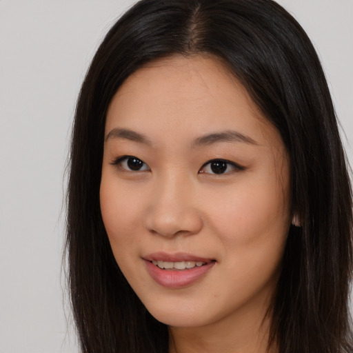 Joyful asian young-adult female with long  brown hair and brown eyes