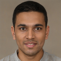 Joyful black young-adult male with short  brown hair and brown eyes