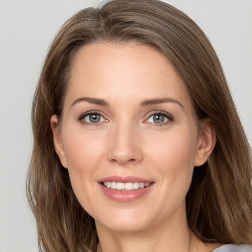 Joyful white young-adult female with long  brown hair and grey eyes